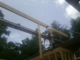 Carpenter setting a ridge beam over a new addition frame — Ice Dam Removal by Roofing Brothers in Westdale