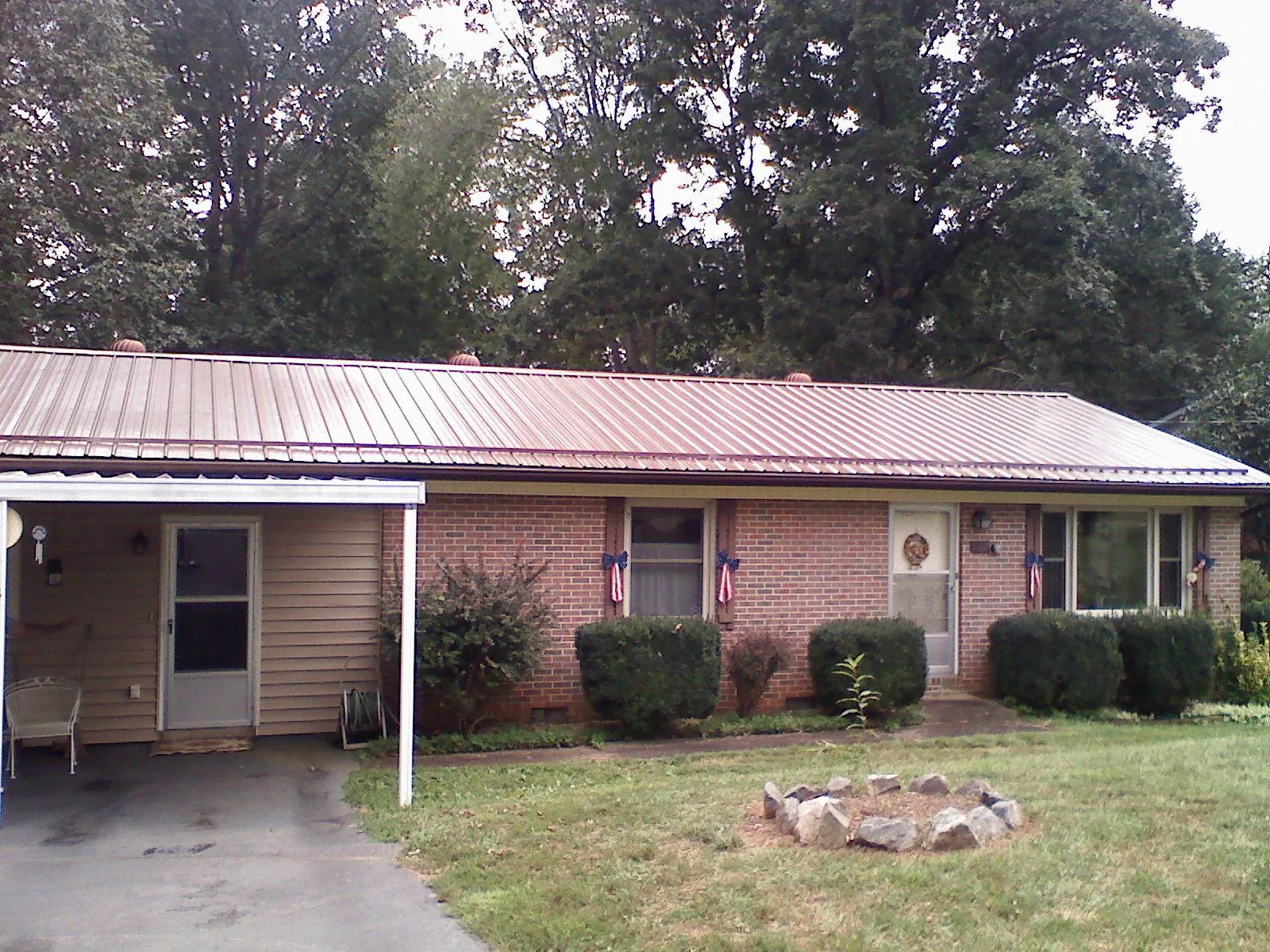 Bronze metal roof and carport on a brick ranch home — Roof Repair work by our crew in Westdale
